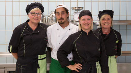 Gruppenfoto: Küchenbrigade in Arbeitskleidung.