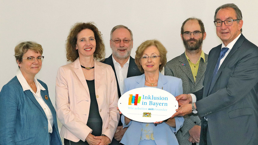 Gruppenfoto: Übergabe des Emblems „Inklusion in Bayern – Wir arbeiten miteinander.“