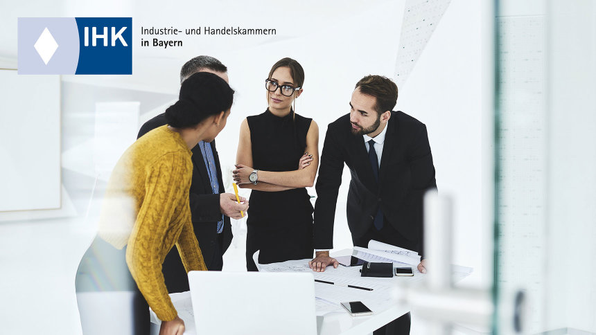 Motiv: Zwei Männer und zwei Frauen stehen um einen Bürotisch und unterhalten sich. Logo: IHK Würzburg-Schweinfurt Mainfranken