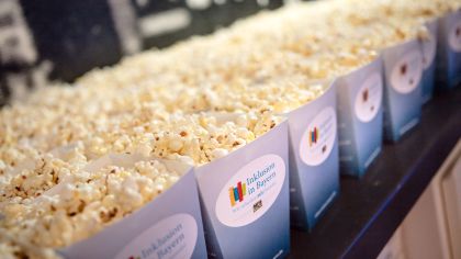 Nahaufnahme: Popcorntüten mit Emblem „Inklusion in Bayern – Wir arbeiten miteinander“.